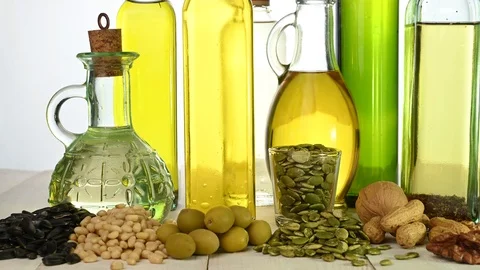 Several bottles of different oil stand on a wooden table Video stock 122097304