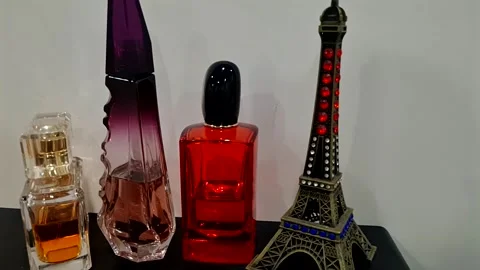 Several bottles of perfume, next to the Eiffel Tower souvenir Stock Footage 287245759