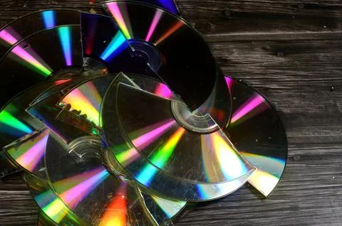 Several broken compact discs CDs that display a rainbow-like effect known a.. Stock Photos