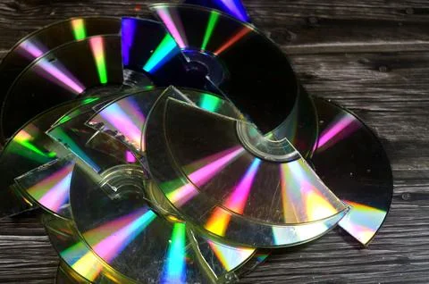 Several broken compact discs CDs that display a rainbow-like effect known a.. Stock Photos