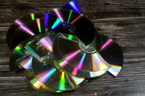 Several broken compact discs CDs that display a rainbow-like effect known a.. Stock Photos
