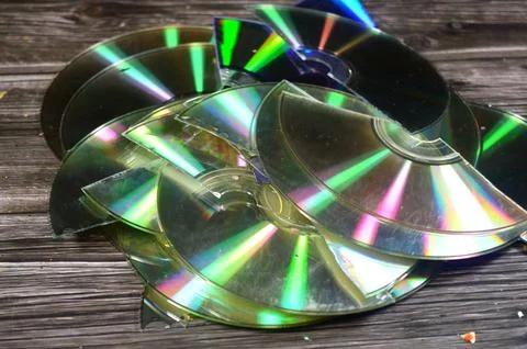 Several broken compact discs CDs that display a rainbow-like effect known a.. Stock Photos