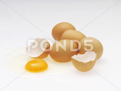 Several brown eggs, one cracked Stock Photos