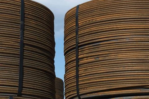 Several bunches of rolled rusty structural steel against a blue sky Severa... Stock Photos