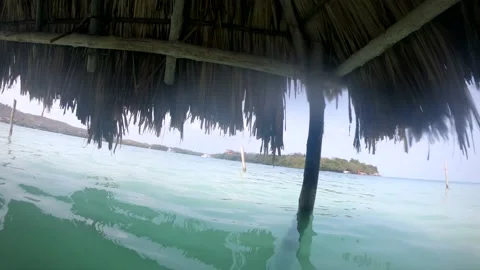 Several cabins or straw huts are in and on the ocean of a paradisiac Vídeo Stock 149065072