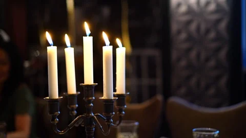 Several candles stand on a candlestick on a table in a restaurant Stock Footage 117297049