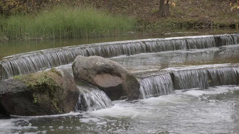 Several cascades of waterfalls on the river in the autumn park Stock Footage