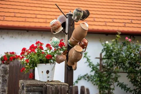 Several ceramic cups stored hanging on a fence in village in Hungary Stock Photos