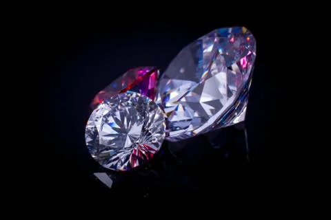 Several chic crystals on a black mirror surface, shimmer and sparkle Stock Photos