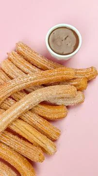 Several churros, close-up, on a pink background Stock Photos