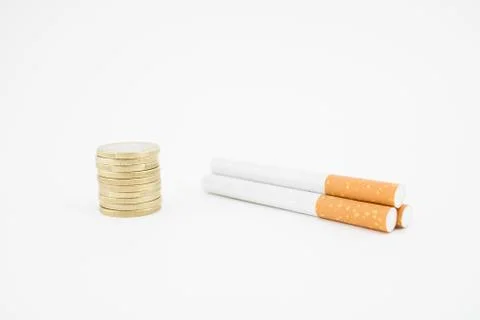 Several cigars and a stack of coins on white background. Economic expenditure Stock Photos