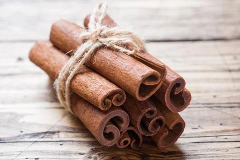 Several cinnamon sticks tied with thread on a wooden background. Copy space.. Foto stock
