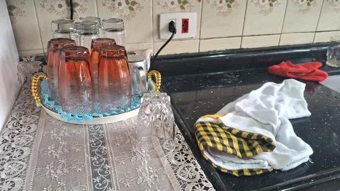 Several clear and orange drinking glasses drying on kitchen counter Stock Photos