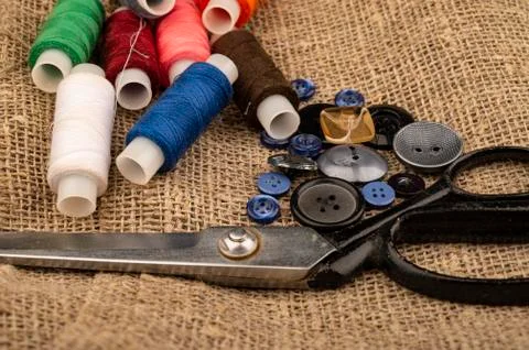 Several colored buttons of different sizes, reels of colored sewing thread, a Stock Photos