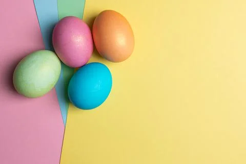 Several colored eggs lie on colored backgrounds Stock Photos