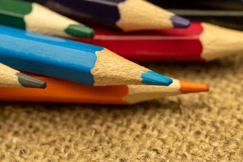Several colored pencils of different colors on a background of coarse burlap Stock Photos