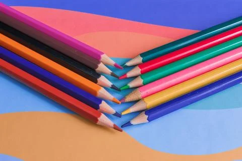 Several colored pencils in a stack on a background of shapes Stock Photos