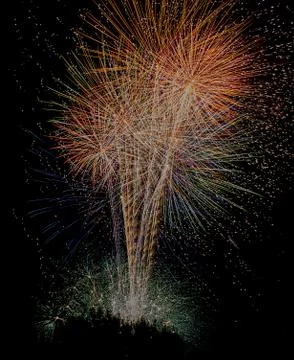 Several colorful fireworks exploding in the dark sky in the midd Stock Photos