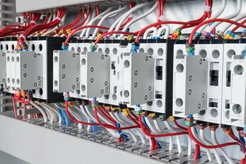 Several contactors arranged in a row in an electrical closet. Stock Photos