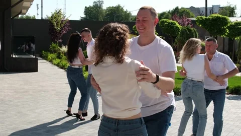 Several couples in jeans and T-shirts dance in nature Guy and girl dance Stock Footage 276907909