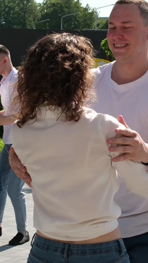 Several couples in jeans and T-shirts dance in nature Guy and girl dance Stock Footage 276962510