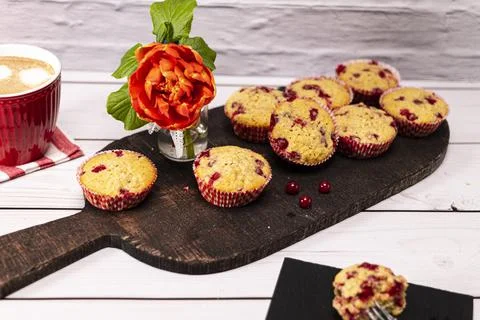 Several currant muffin served on a rustic board with a cup of cappuccino Stock Photos