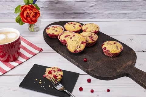 Several currant muffin served on a rustic board with a cup of cappuccino Stock Photos