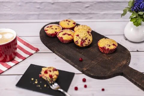 Several currant muffin served on a rustic board with a cup of cappuccino Stock Photos