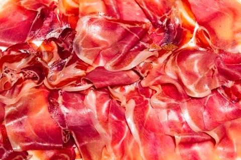 Several delicious thin slices of typical spanish ham. Traditional food and fl Stock Photos