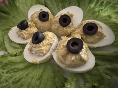  Several deviled eggs, topped with sliced black olives, are beautifully ar... 스톡 사진