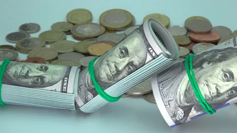 Several of dollar banknotes in rolls with rubber bands and coins on table Stock Footage 131503115