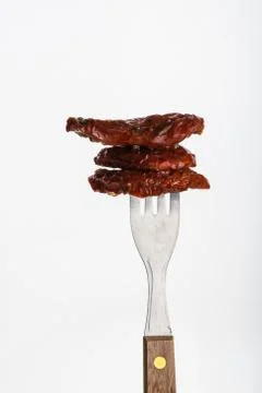 Several dried tomatoes impaled on fork Stock Photos