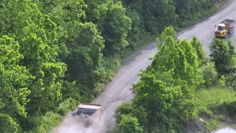 Several dump trucks transporting quarry and of mining area in America. Sunset Stock Footage 314302949