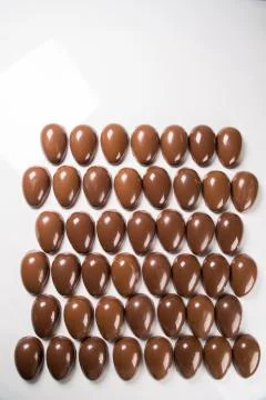 Several easter eggs in the chocolate factory Stock Photos
