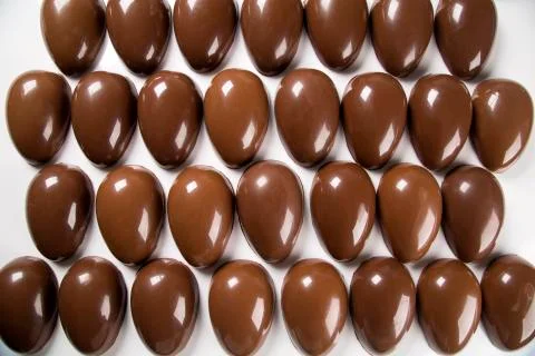 Several easter eggs in the chocolate factory Stock Photos