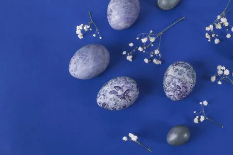 Several easter marbled purple eggs on a blue background with copy space Foto stock