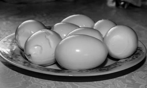 Several eggs out of their shells, lying on  plate Stock Photos