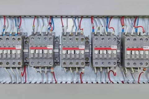 Several electrical contactor on a mounting panel in electrical closet. Stock Photos