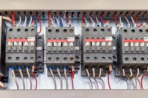 Several electrical contactor on a mounting panel in electrical closet. Stock Photos