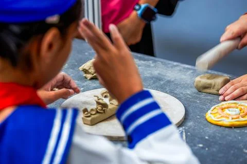 Several elementary school students sat together making pottery. Foto stock