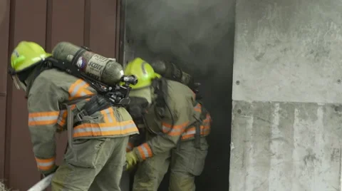Several Fire Fighters pull a hose in a burning building  스톡 동영상 57214930