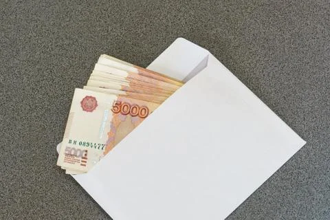 Several five thousandth ruble notes in a clean white envelope laying on a gra Foto stock