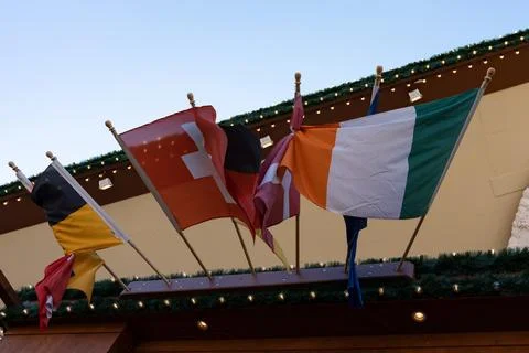 Several flags of different countries intertwine together in the wind. Stock Photos