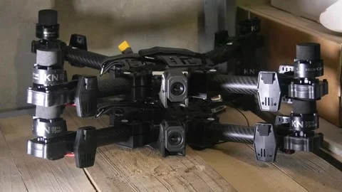 Several FPV attack drones stacked on a shelf inside a military dugout workshop. Stock Footage 346809947