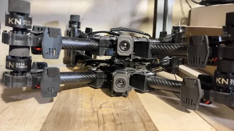 Several FPV attack drones stacked on a shelf inside a military dugout workshop. 库存影片 346809984