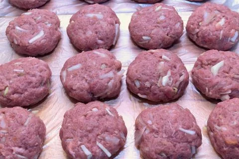 Several fresh cutlets of meat, beef, pork lie on the Board in several rows. Stock Photos