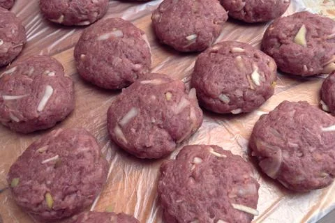 Several fresh cutlets of meat, beef, pork lie on the Board in several rows. Stock Photos