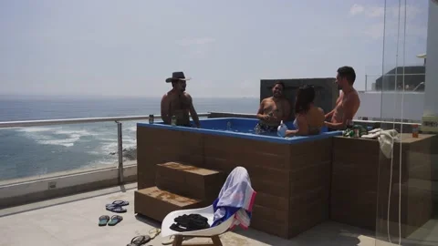 Several friends drinking cans of Pilsen beer and wine in the pool on the terrace Stock Footage 186236207