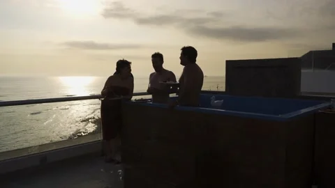 Several friends eating and drinking smiling and talking in the pool on the Stock Footage 189097170