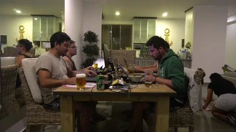 Several friends playing and working with their laptops at the dining room table Stock Footage 194501898